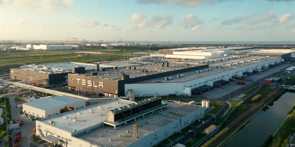 Tesla Gigafactory in Shanghai with rows of electric vehicles parked outside the modern facility