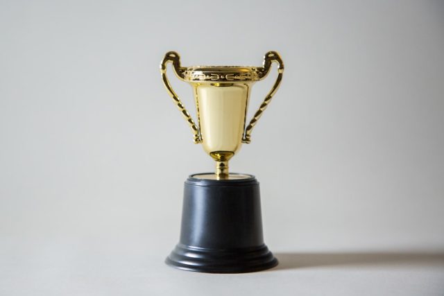 Maybank Investment Bank wins six top industry awards despite pandemic challenges Maybank Investment Bank trophy display with award plaques on a dark wooden shelf.