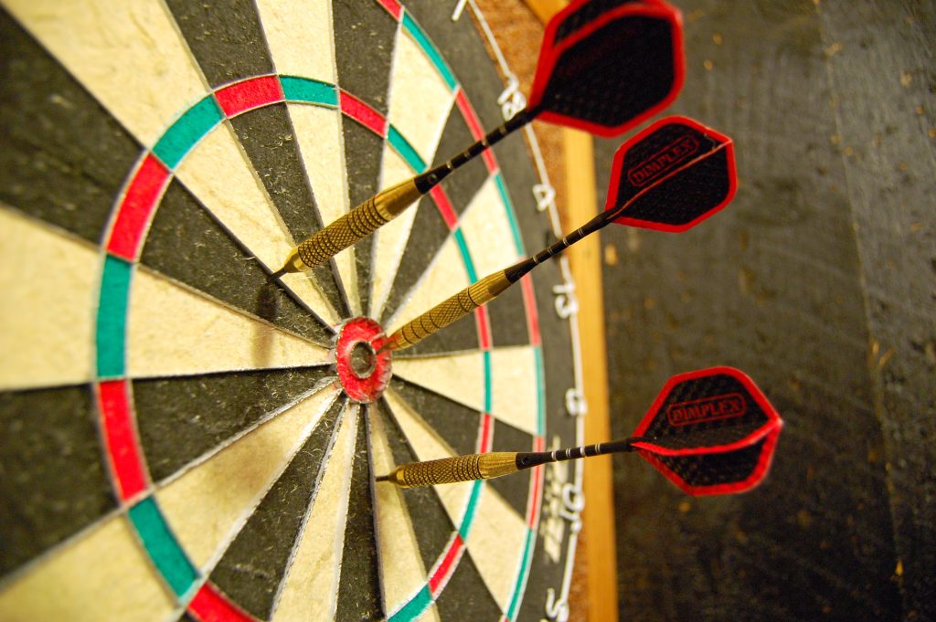 Darts Player Throwing Darts At A Dartboard